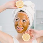 concept-soins-peau-beaute-jolie-femme-race-blanche-dans-serviette-blanche-masque-facial-brun-visage-contient-agrumes-sa-main-espace-lumineux-procedures-spa-masque-creme-peau_161094-1975